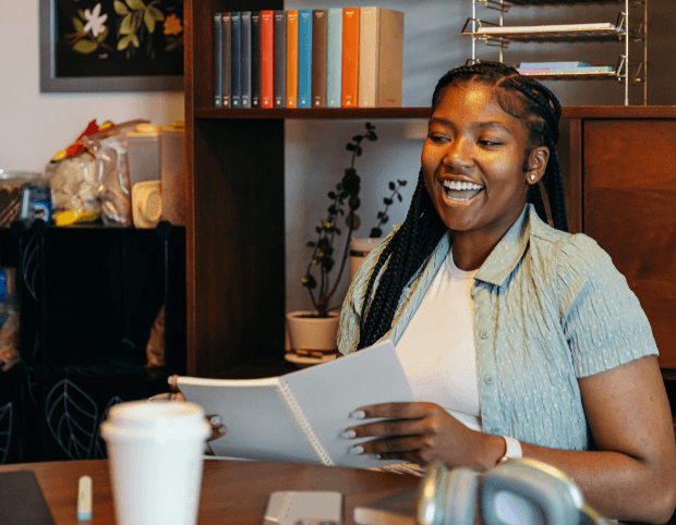 A TCGi scholar smiling as she reads through her notes